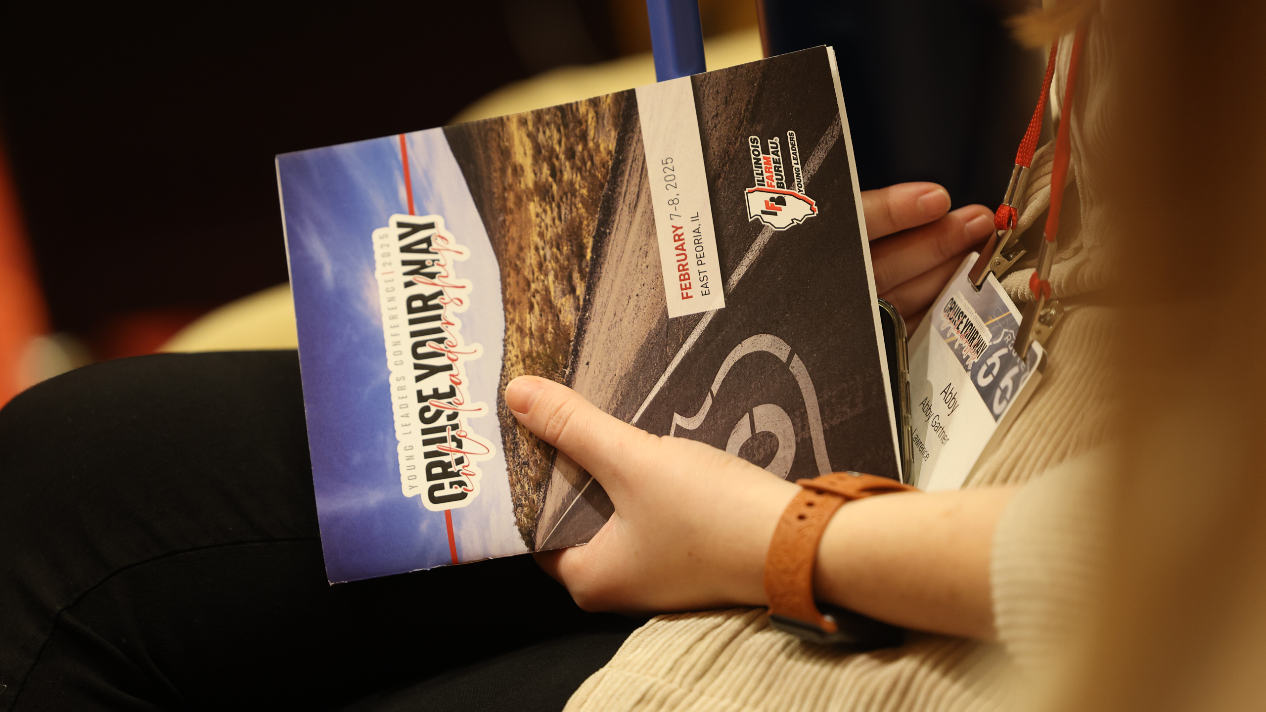 Close up of a woman holding a brochure at a conference. 