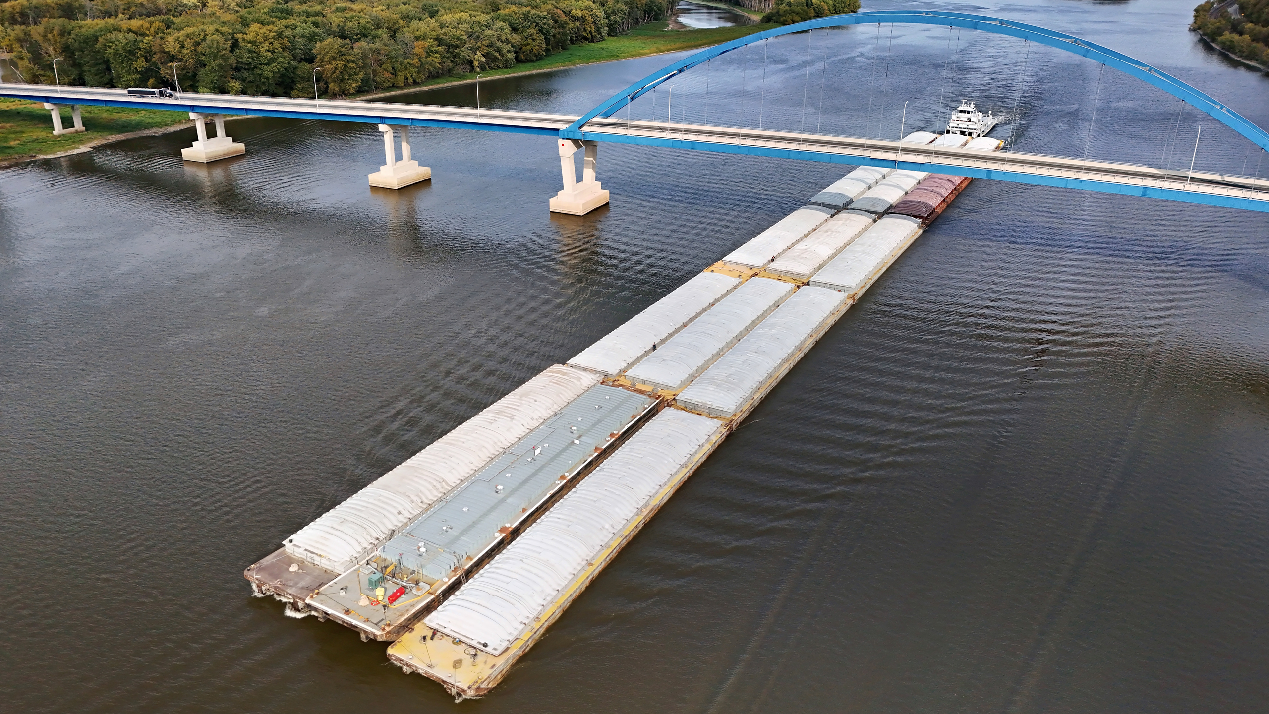 A barge going up the river under a bridge.