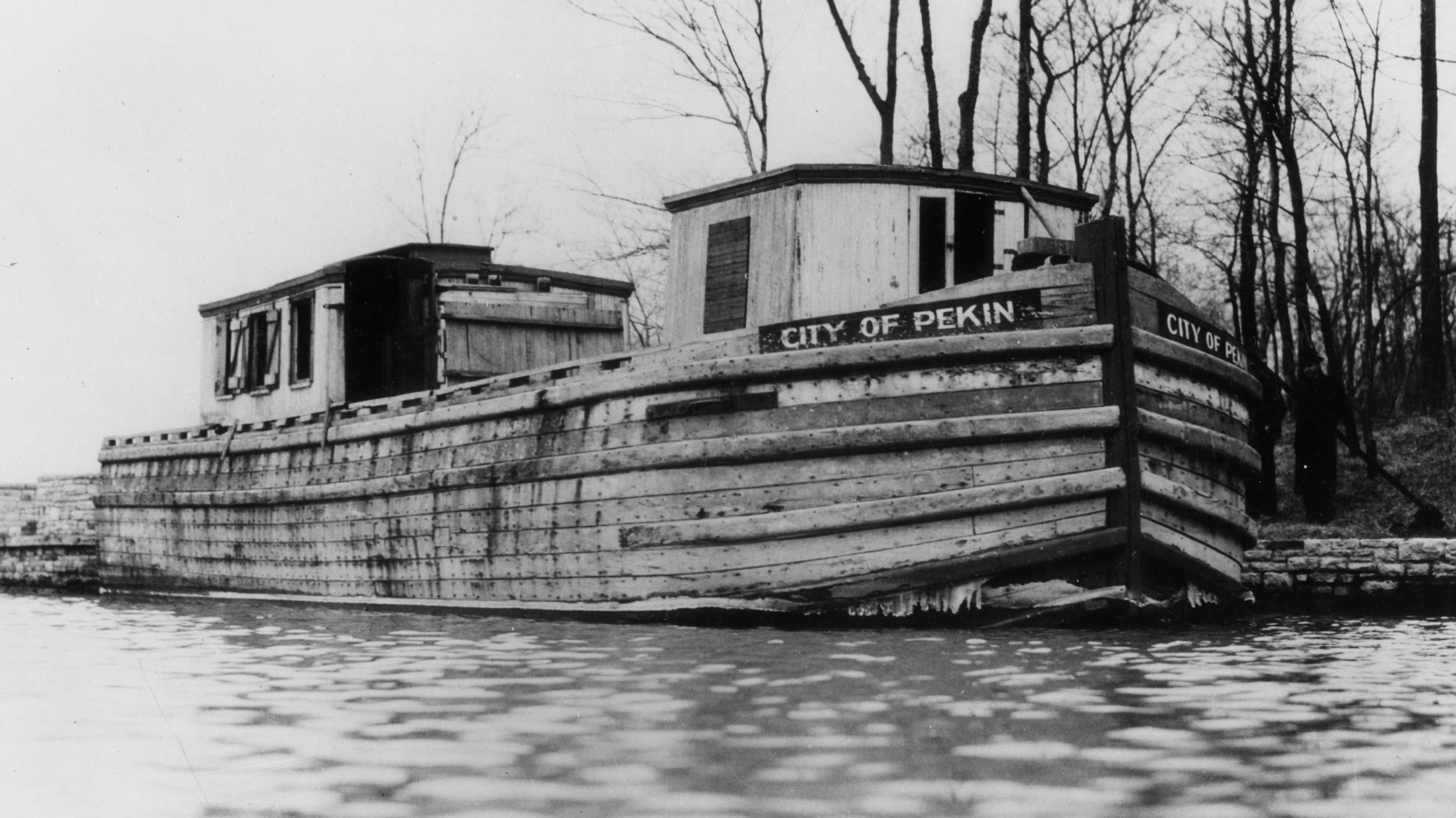 Old black and white photo of the city of pekin's canal boat in the Illinois River.