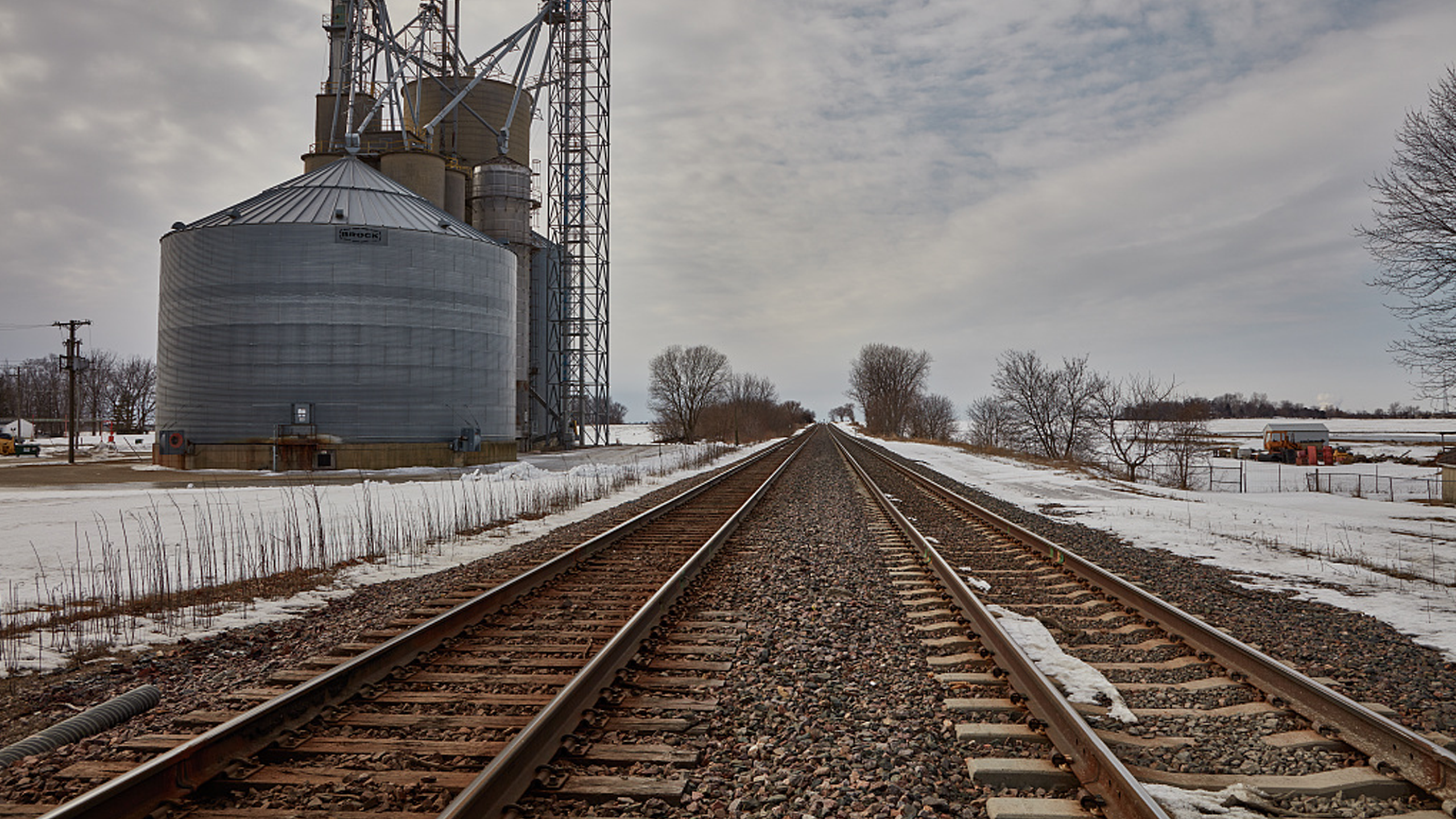 Wintery Scene of train tracks in the midwest with a grain bin in the background