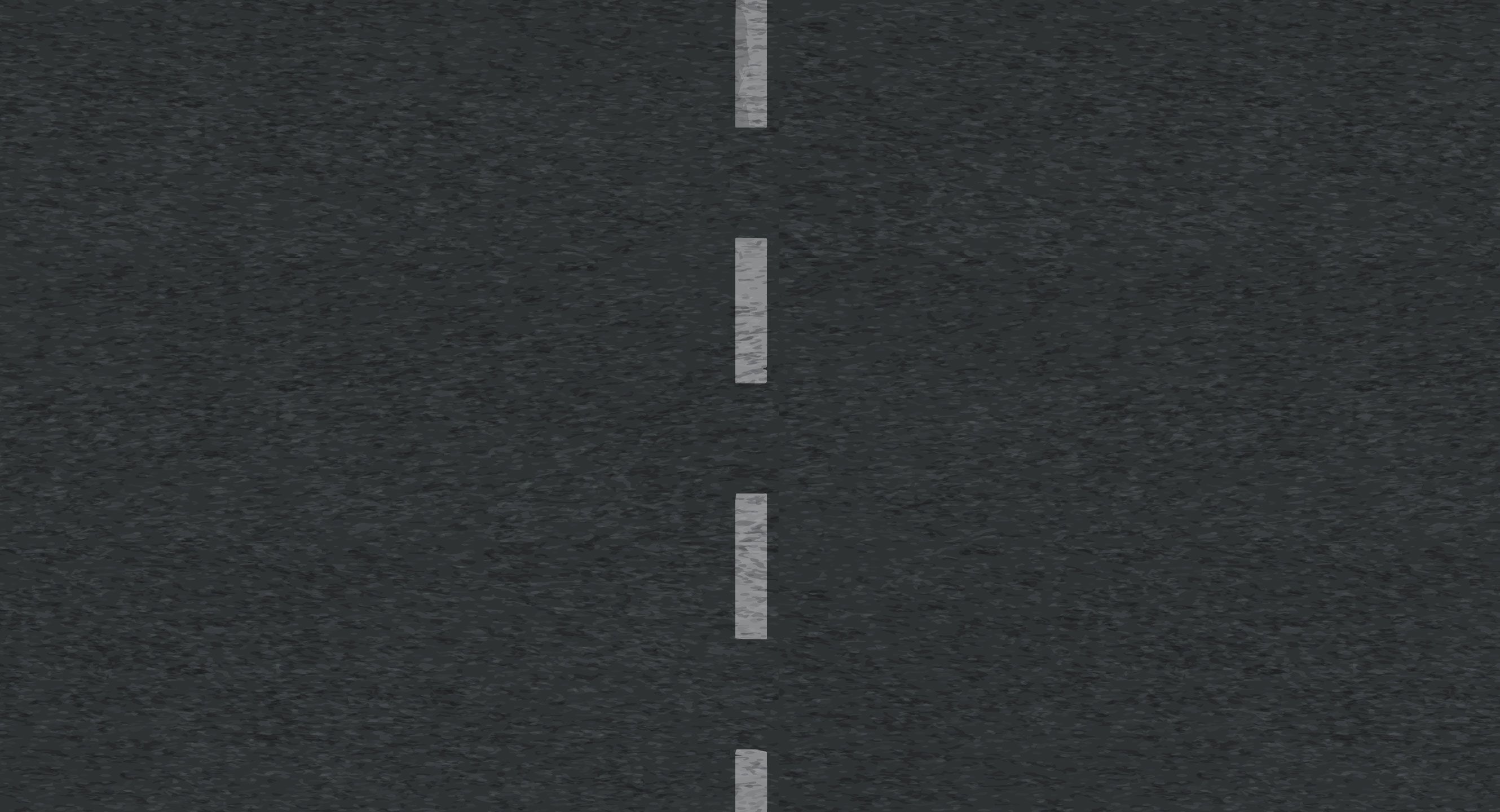 Arial view of an asphalt road with white dotted lines going down the middle.